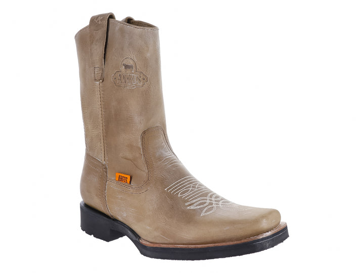 Bota vaquera de cuero color latón con suela negra y detalle de marca Angus.