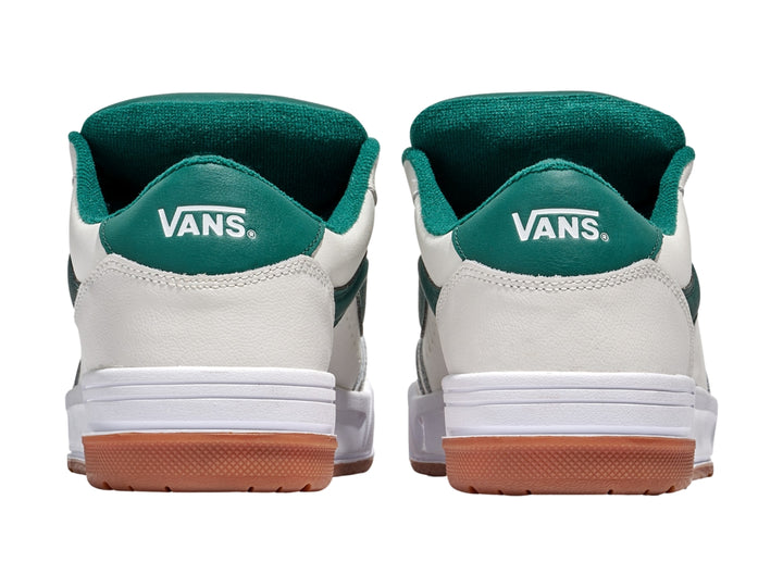 Tenis Vans blancos con franja y cordones verdes y suela de goma color marrón.