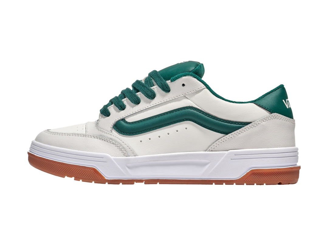 Tenis Vans blancos con franja y cordones verdes y suela de goma color marrón.