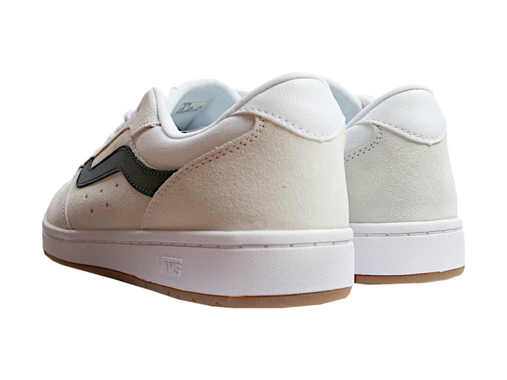 Tenis Vans blancos con franja lateral negra y suela de goma color miel.