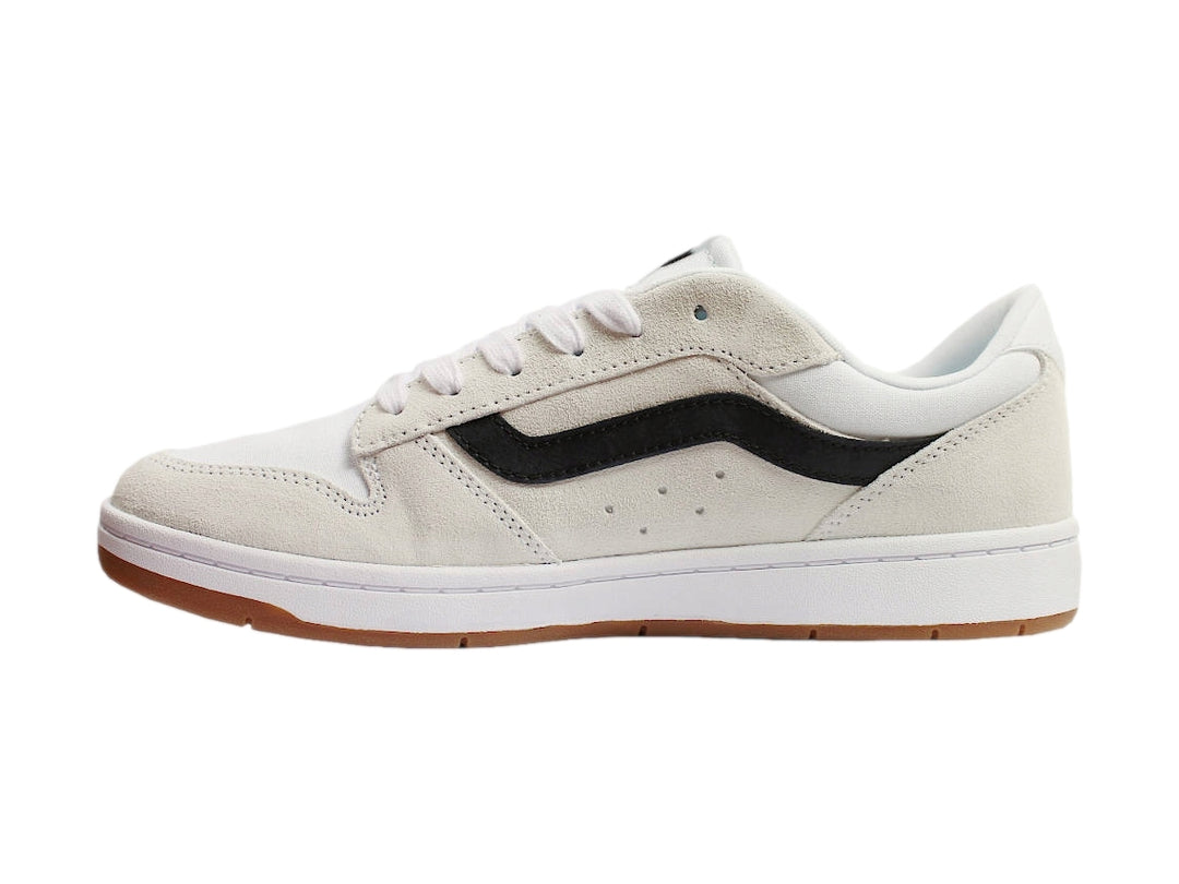 Tenis Vans blancos con franja lateral negra y suela de goma color miel.