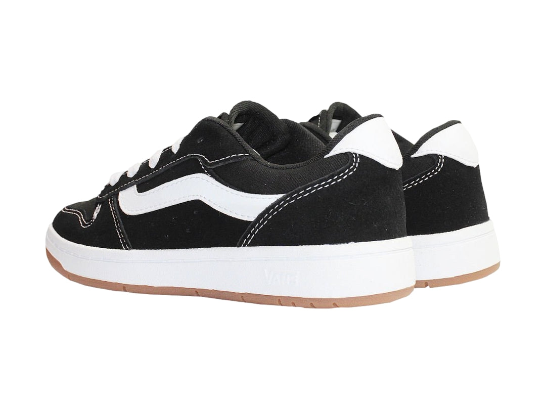 Tenis Vans Ryland color negro con franja lateral blanca y suela de goma color café.