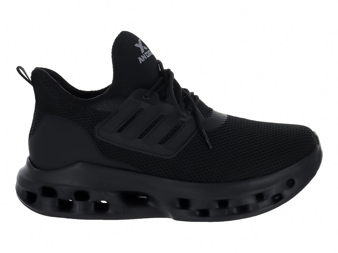 Tenis deportivos Andrax color negro con suela gruesa perforada y tejido de malla.