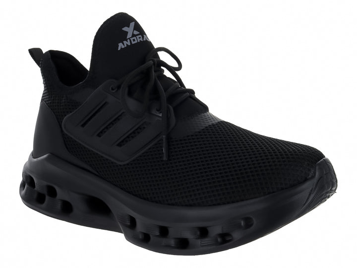 Tenis deportivos Andrax color negro con suela gruesa perforada y tejido de malla.