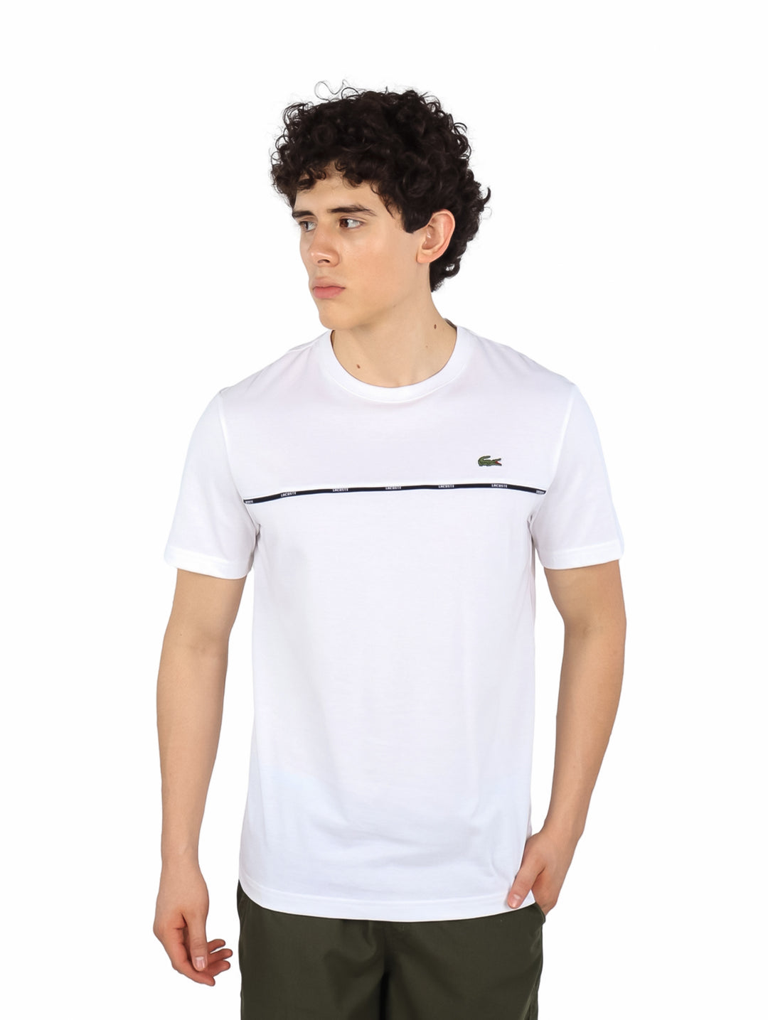 Hombre vistiendo camiseta blanca de manga corta Lacoste con una línea horizontal oscura en el pecho.