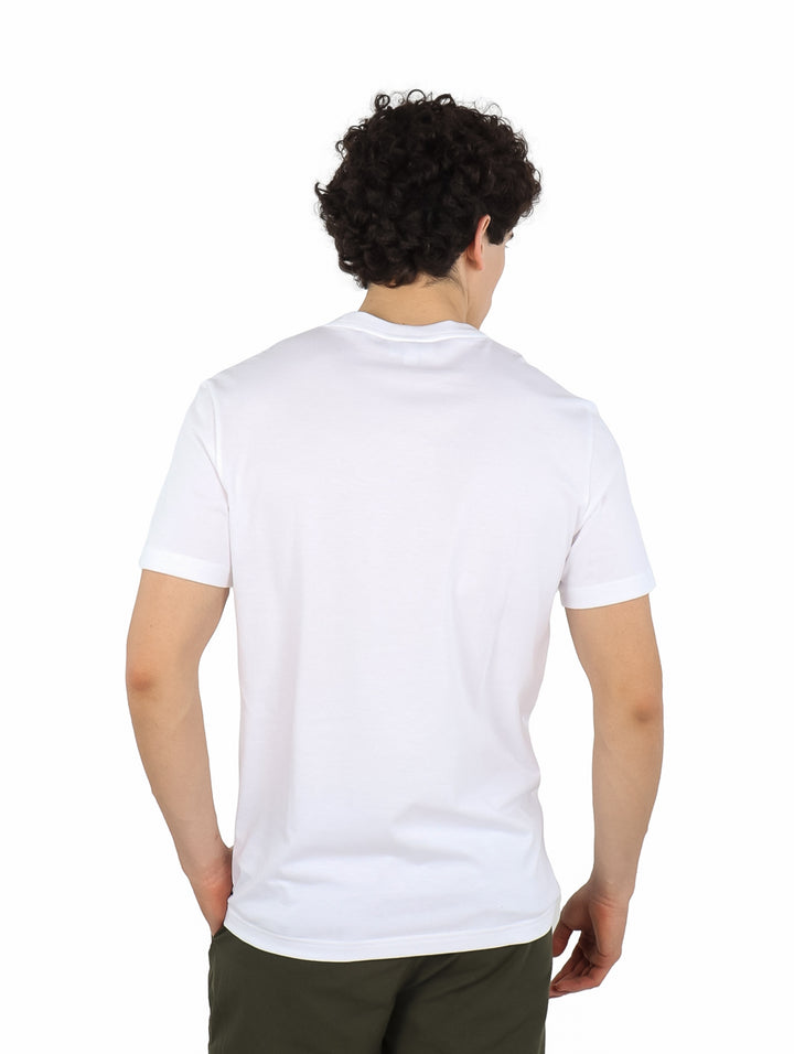 Hombre vistiendo camiseta blanca de manga corta Lacoste con una línea horizontal oscura en el pecho.