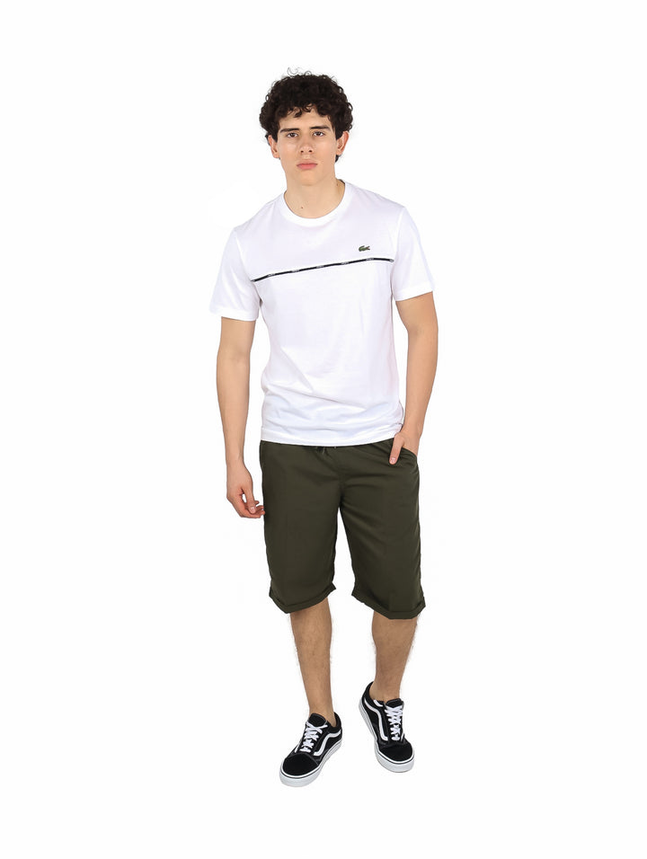 Hombre vistiendo camiseta blanca de manga corta Lacoste con una línea horizontal oscura en el pecho.