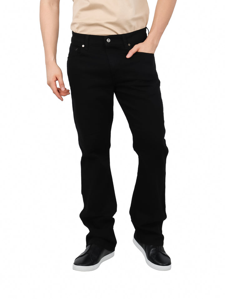 Hombre vistiendo pantalones LEE color negro con corte boot cut y calzado oscuro sobre fondo blanco.