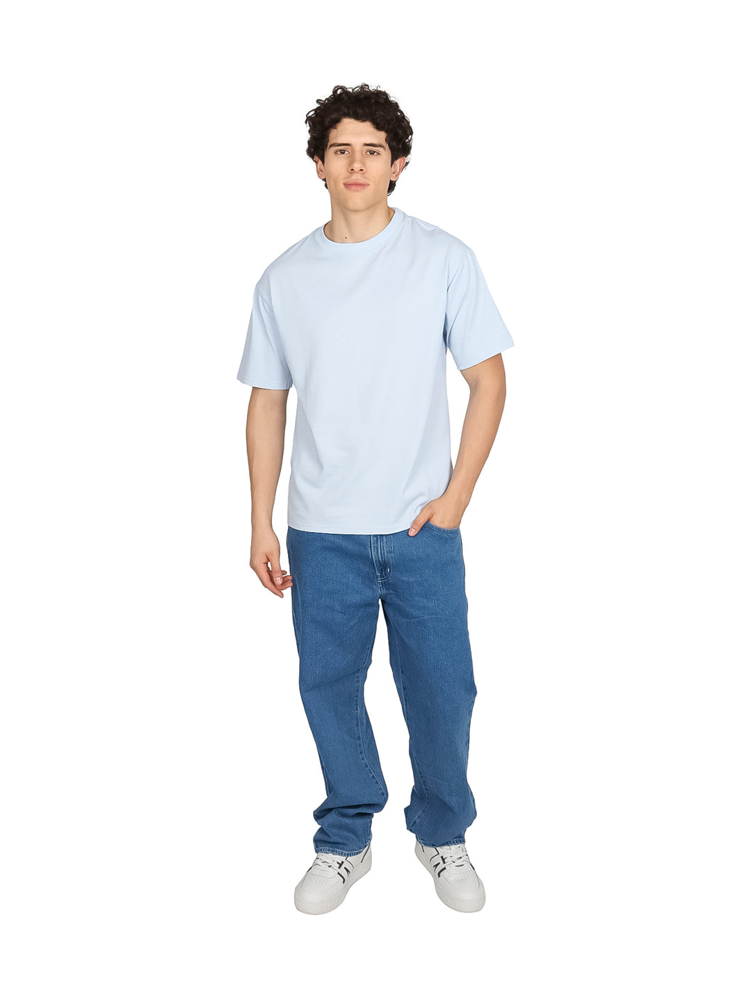 Hombre vistiendo pantalones jeans de color azul claro con tenis blancos.