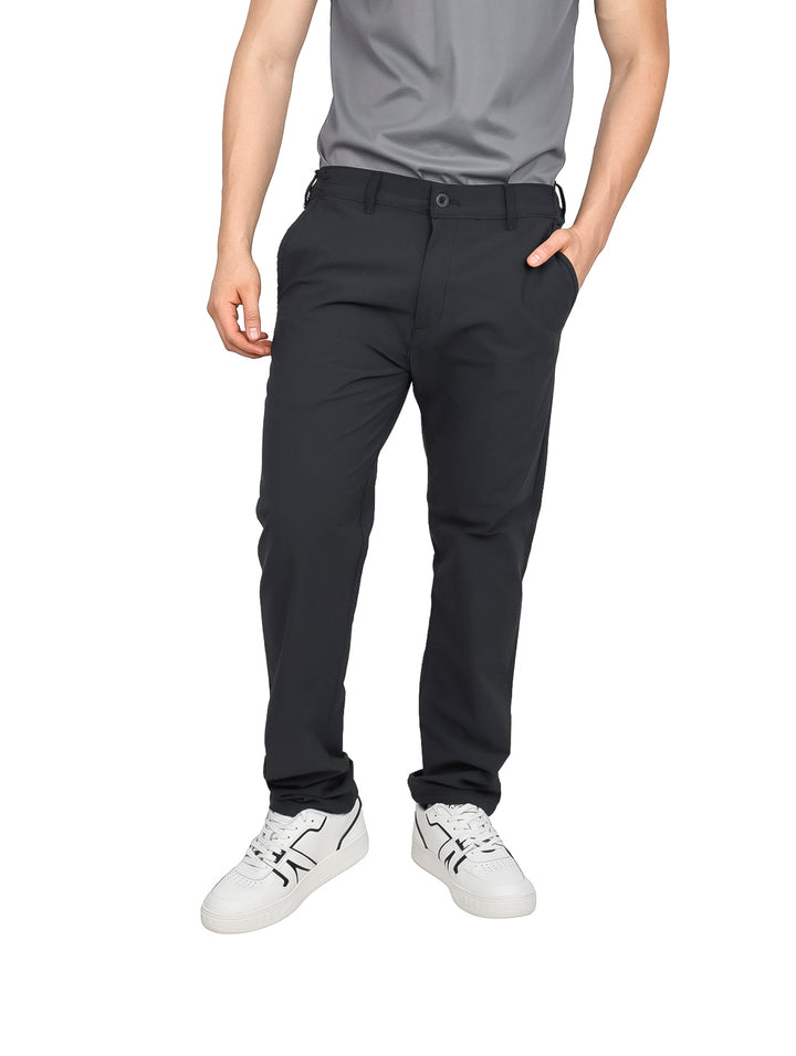 Hombre vistiendo pantalones negros de corte recto con tenis blancos y camiseta gris.