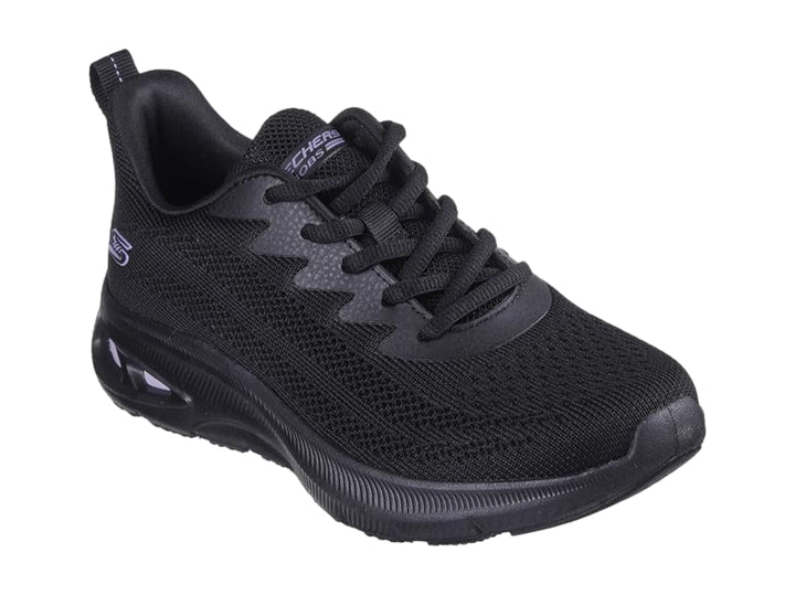 Tenis deportivos Skechers color negro con detalles en morado en la suela y tejido transpirable.