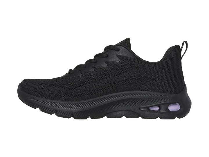 Tenis deportivos Skechers color negro con detalles en morado en la suela y tejido transpirable.