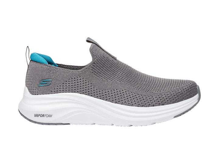Zapato deportivo SKECHERS color gris con suela blanca y detalles en azul, estilo slip-on.