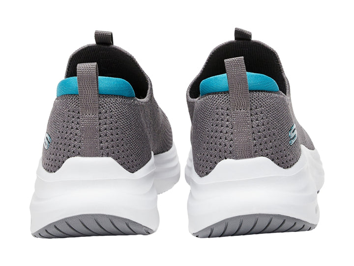 Zapato deportivo SKECHERS color gris con suela blanca y detalles en azul, estilo slip-on.
