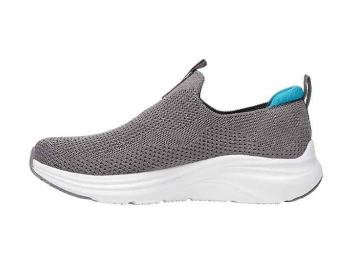 Zapato deportivo SKECHERS color gris con suela blanca y detalles en azul, estilo slip-on.