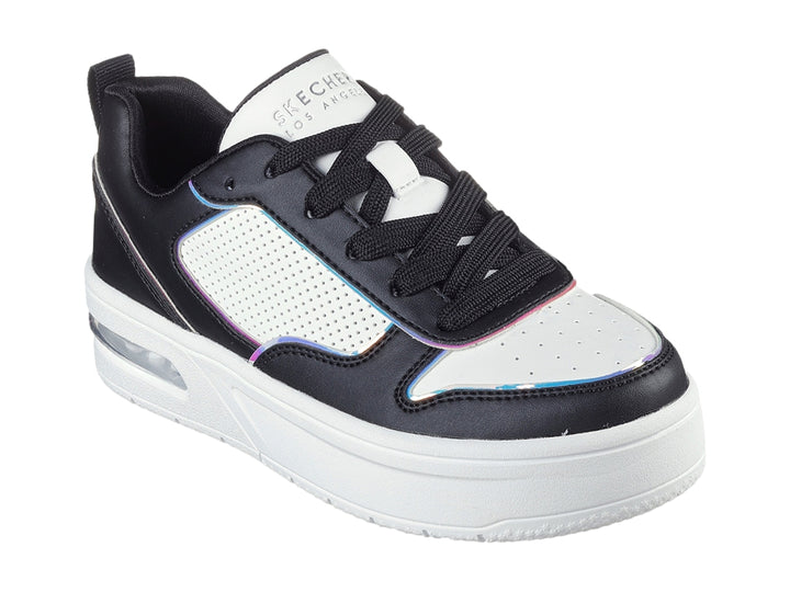 Tenis Skechers color negro y blanco con detalles en azul, suela blanca de plataforma y cámara de aire visible.