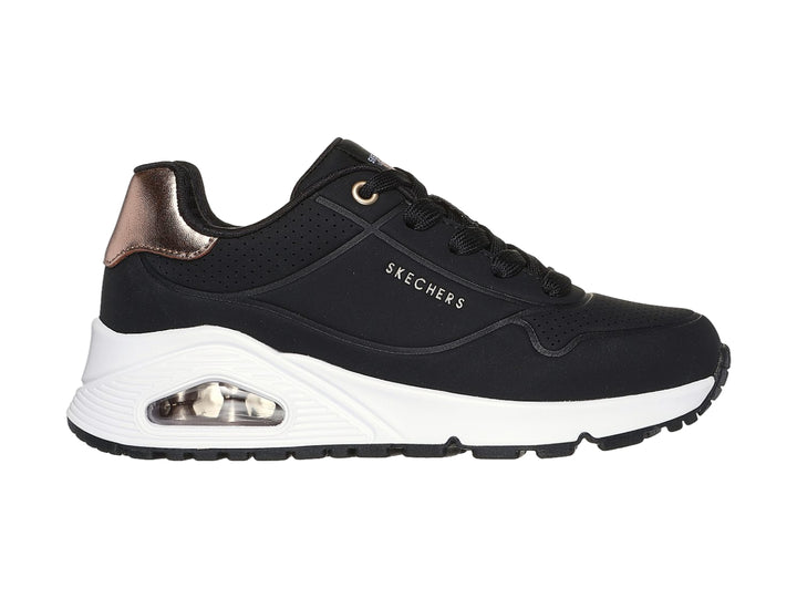 Tenis deportivos Skechers color negro con suela blanca y detalle metalizado en el talón.