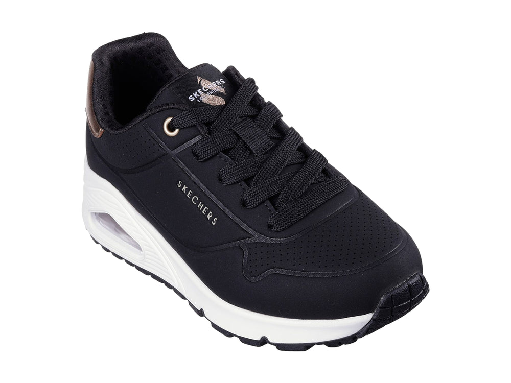 Tenis deportivos Skechers color negro con suela blanca y detalle metalizado en el talón.