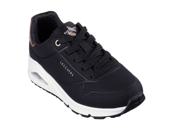 Tenis deportivos Skechers color negro con suela blanca y detalle metalizado en el talón.