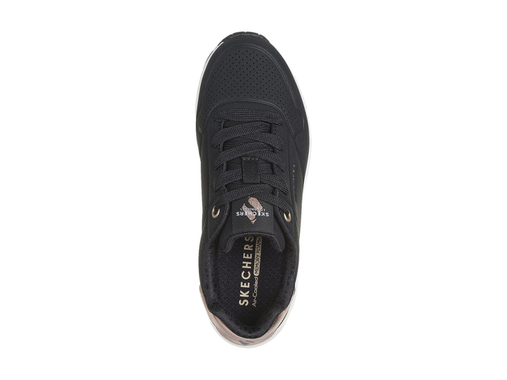 Tenis deportivos Skechers color negro con suela blanca y detalle metalizado en el talón.