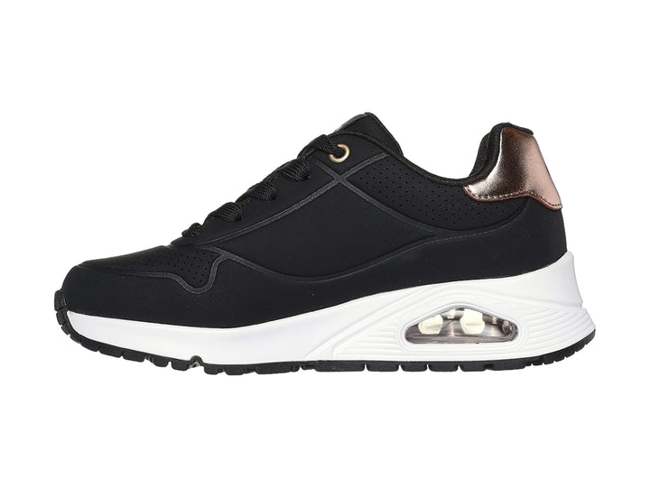 Tenis deportivos Skechers color negro con suela blanca y detalle metalizado en el talón.