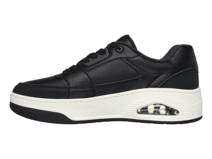 Tenis Skechers color negro con suela blanca gruesa y detalle en turquesa en el talón.