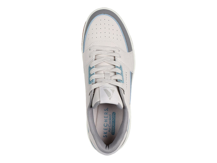 Tenis Skechers One Court color beige y gris con suela marrón y cámara de aire en el talón.