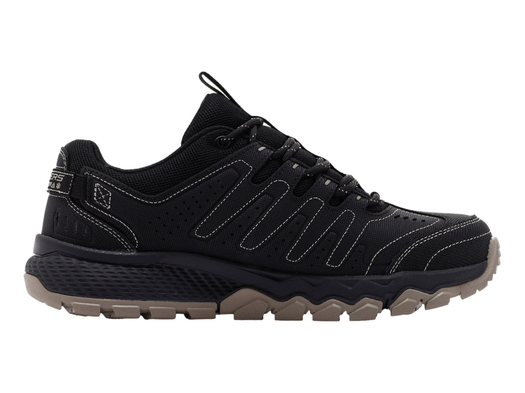 Zapato deportivo Skechers color negro con suela rugosa en tono beige.