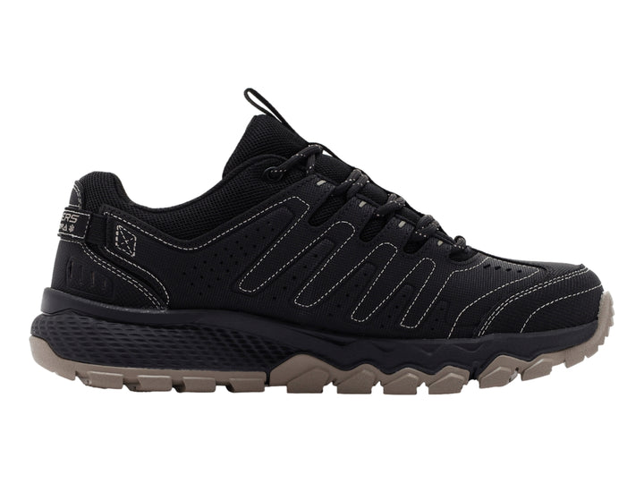 Zapato deportivo Skechers color negro con suela rugosa en tono beige.