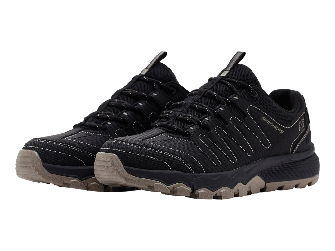 Zapato deportivo Skechers color negro con suela rugosa en tono beige.