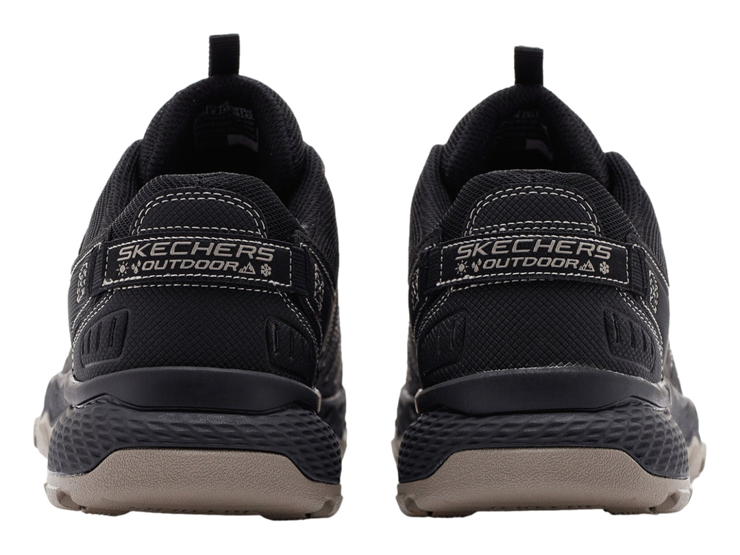 Zapato deportivo Skechers color negro con suela rugosa en tono beige.