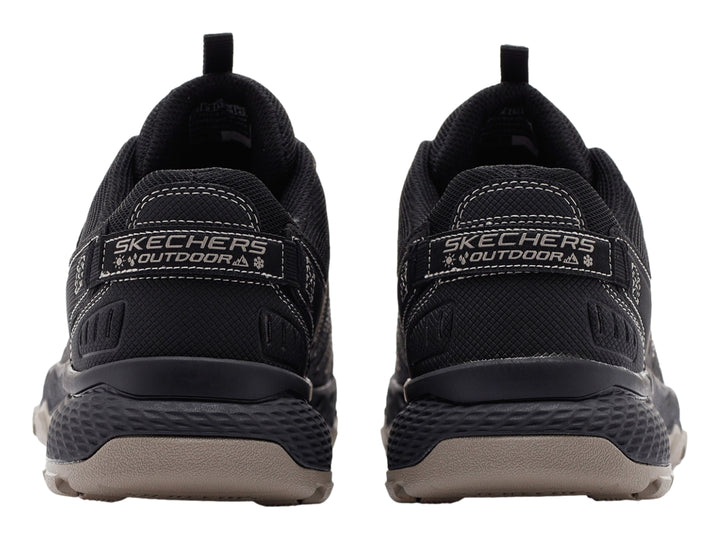 Zapato deportivo Skechers color negro con suela rugosa en tono beige.