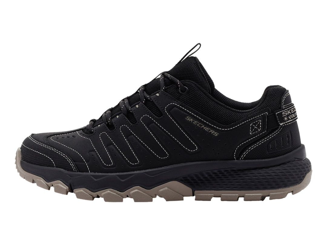 Zapato deportivo Skechers color negro con suela rugosa en tono beige.