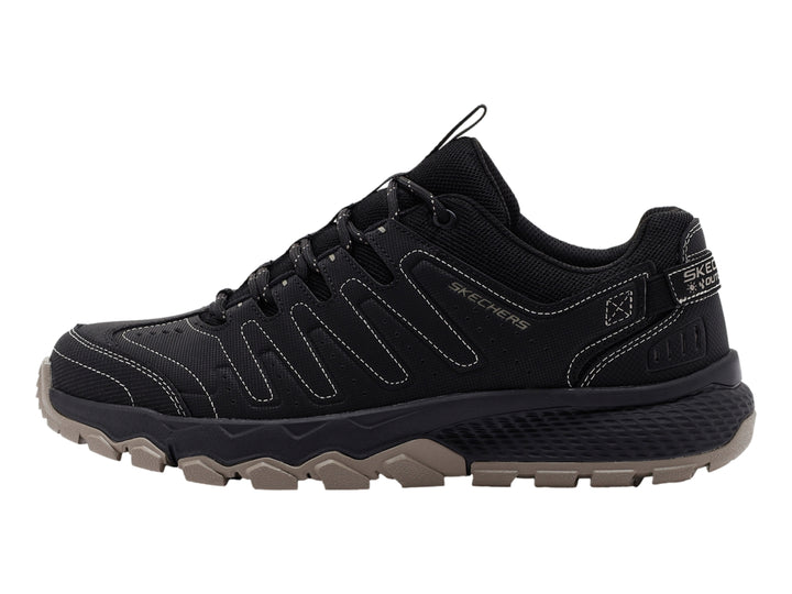 Zapato deportivo Skechers color negro con suela rugosa en tono beige.