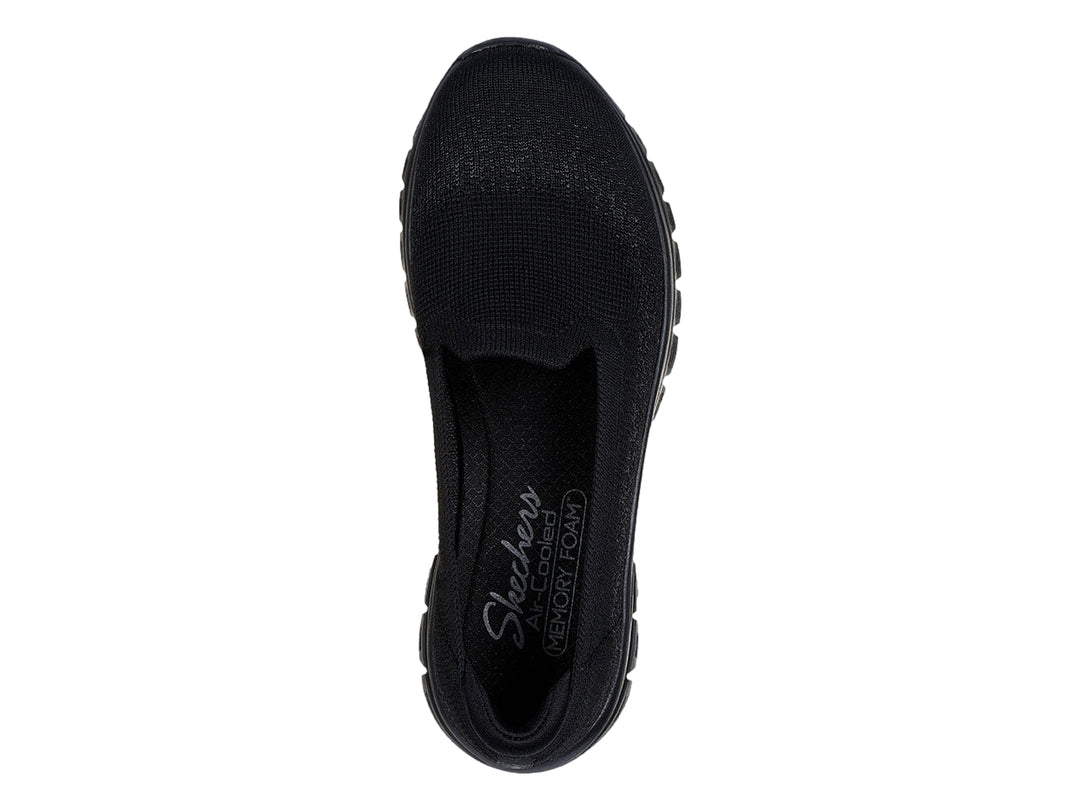 Zapato deportivo SKECHERS color negro, estilo slip-on con tejido transpirable y suela gruesa.