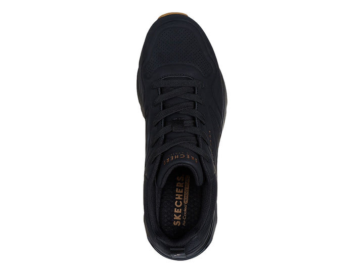 Tenis Skechers negros para hombre con cámara de aire visible en la suela y base color café.