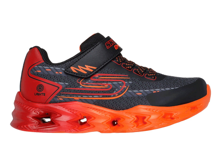 Tenis deportivos SKECHERS infantiles color negro con suela y detalles en rojo brillante.