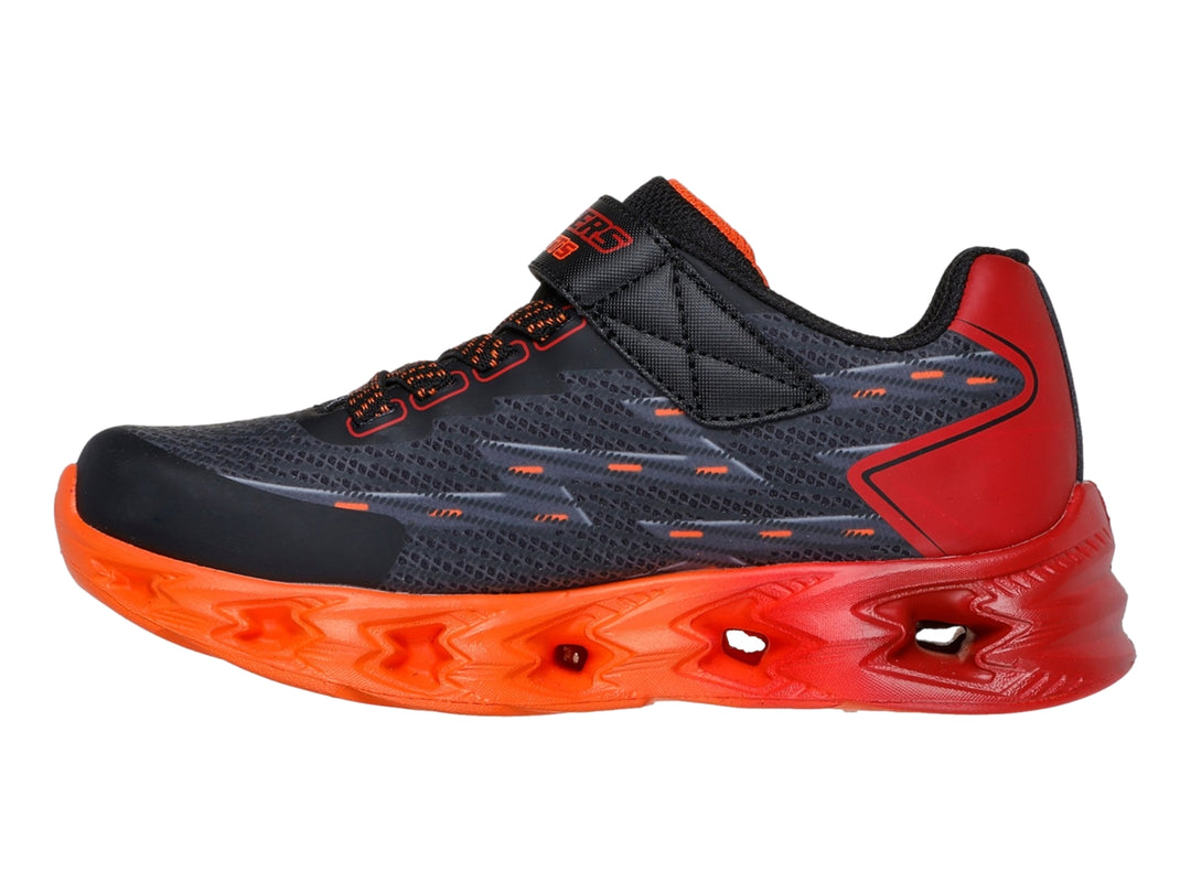 Tenis deportivos SKECHERS infantiles color negro con suela y detalles en rojo brillante.