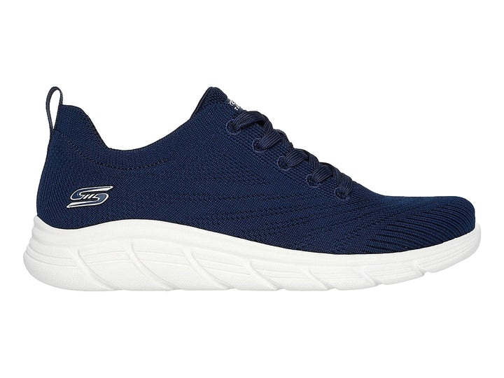 Tenis Skechers azul marino con suela blanca y cordones, diseño deportivo y tejido transpirable.