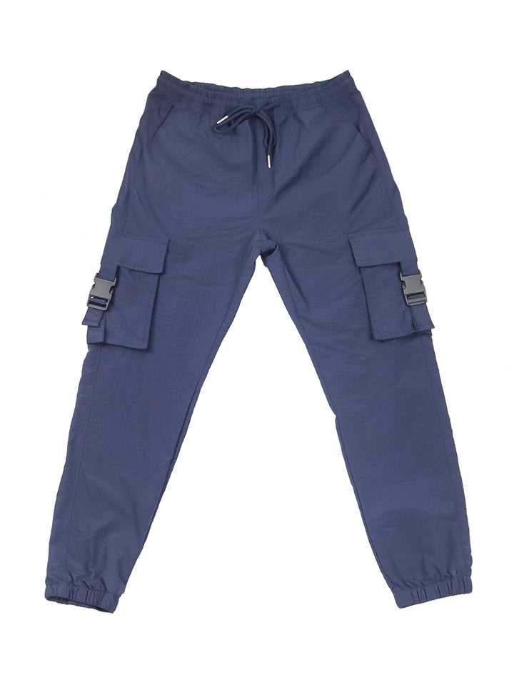 Hombre vistiendo pantalón jogger cargo color azul marino con camiseta blanca y tenis beige.