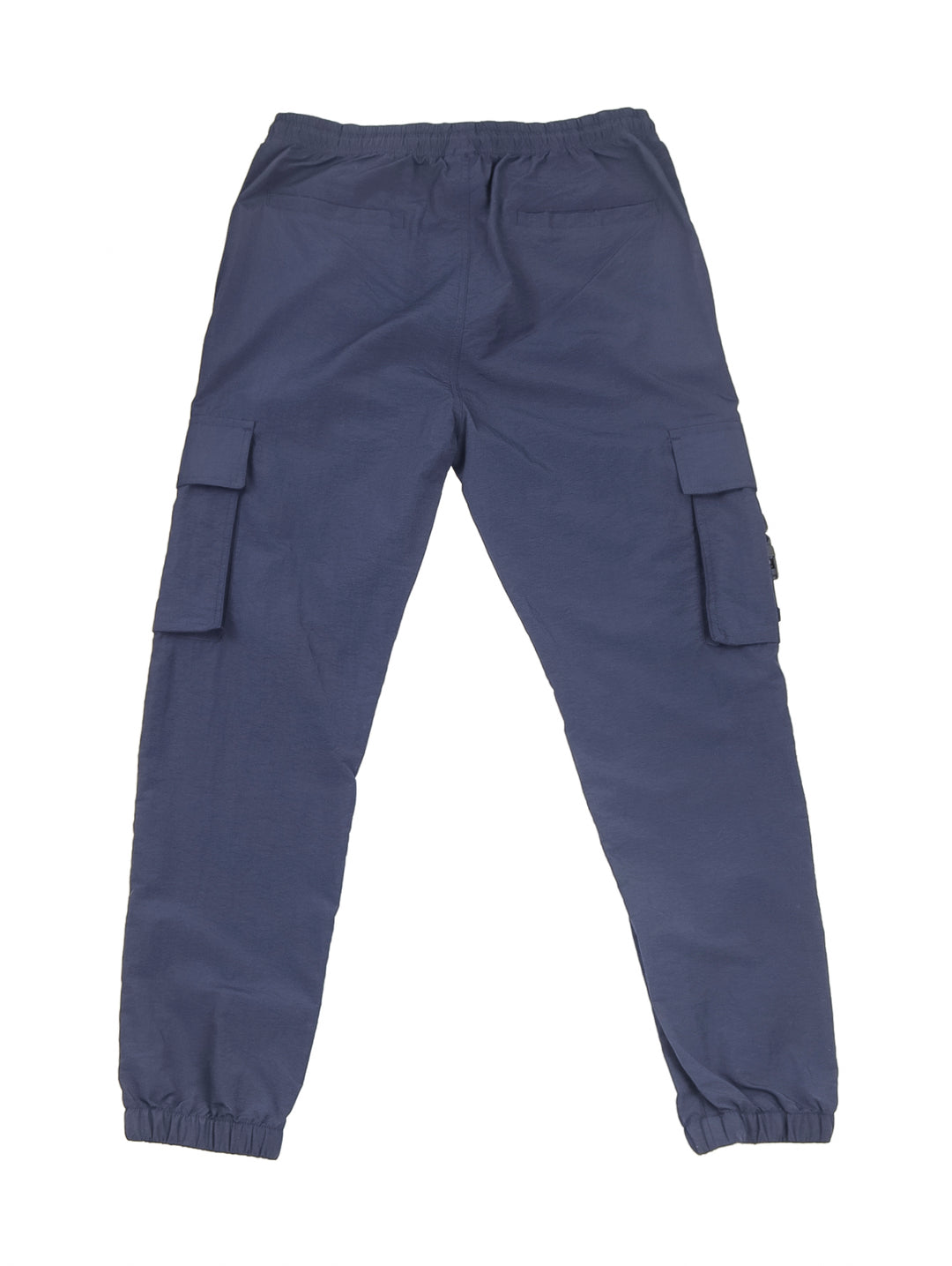 Hombre vistiendo pantalón jogger cargo color azul marino con camiseta blanca y tenis beige.