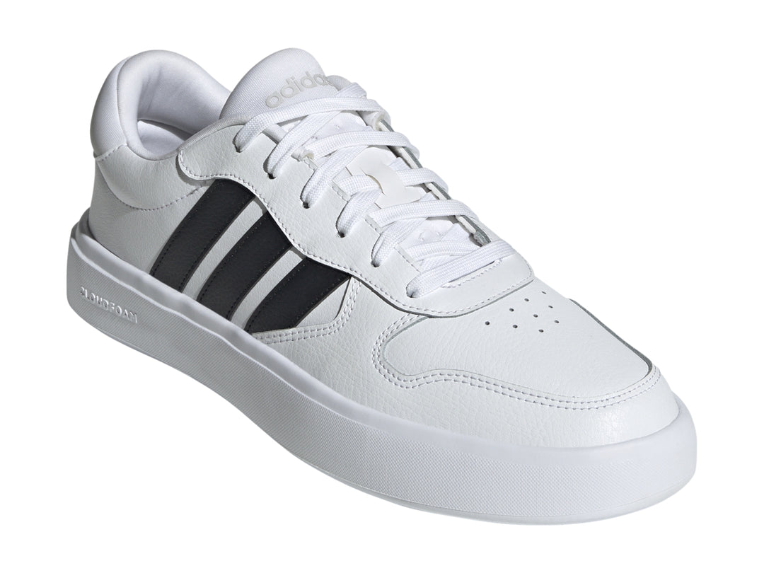 Tenis Adidas Litecourt en color blanco con tres franjas negras laterales y suela blanca.