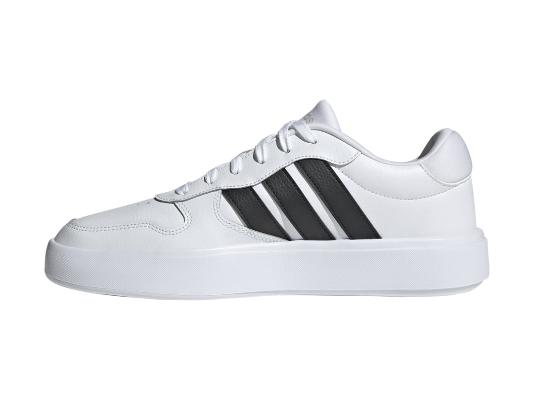 Tenis Adidas Litecourt en color blanco con tres franjas negras laterales y suela blanca.