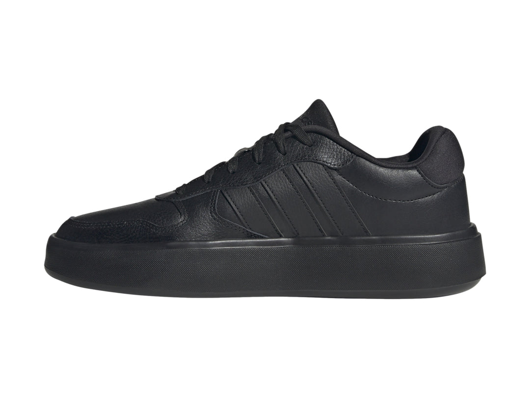 Tenis Adidas Litecourt color negro total con acabado texturizado y suela plana.
