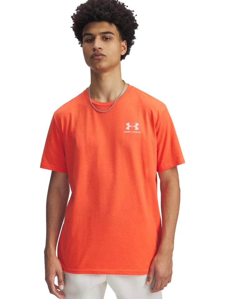 Hombre vistiendo una playera deportiva de manga corta color naranja con logotipo blanco de Under Armour en el pecho.