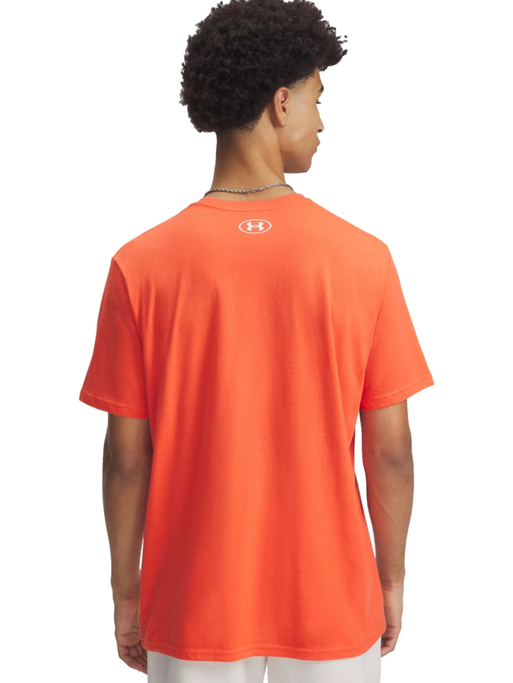Hombre vistiendo una playera deportiva de manga corta color naranja con logotipo blanco de Under Armour en el pecho.