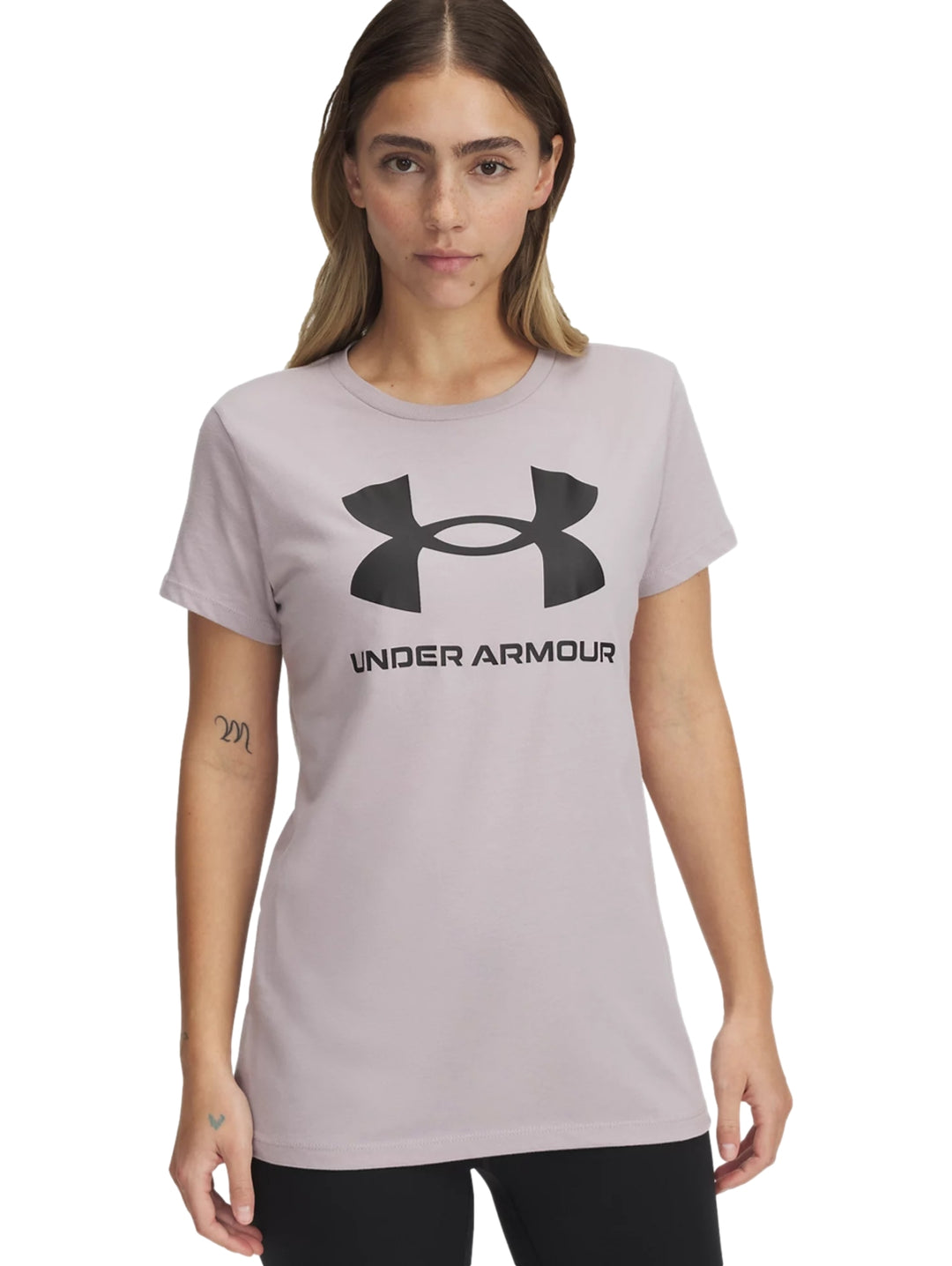 Camiseta Under Armour color gris dawn con logotipo negro en el pecho, modelo mujer.