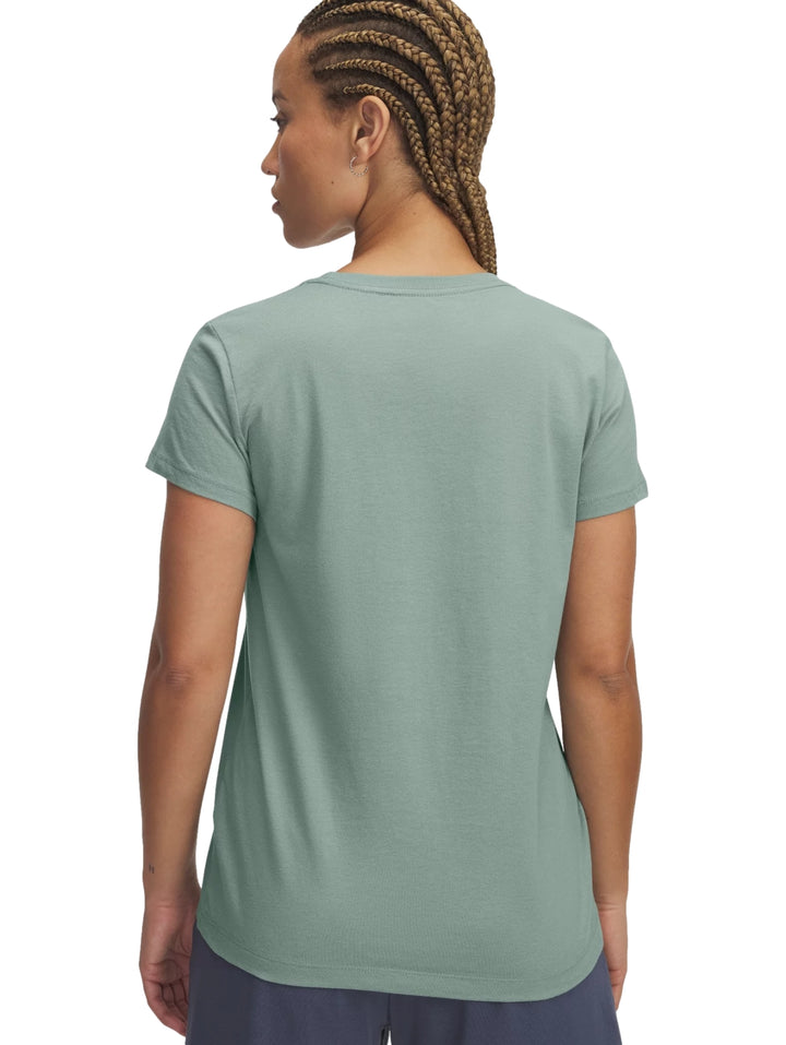 Mujer vistiendo una camiseta deportiva verde claro con logotipo de Under Armour en el centro.