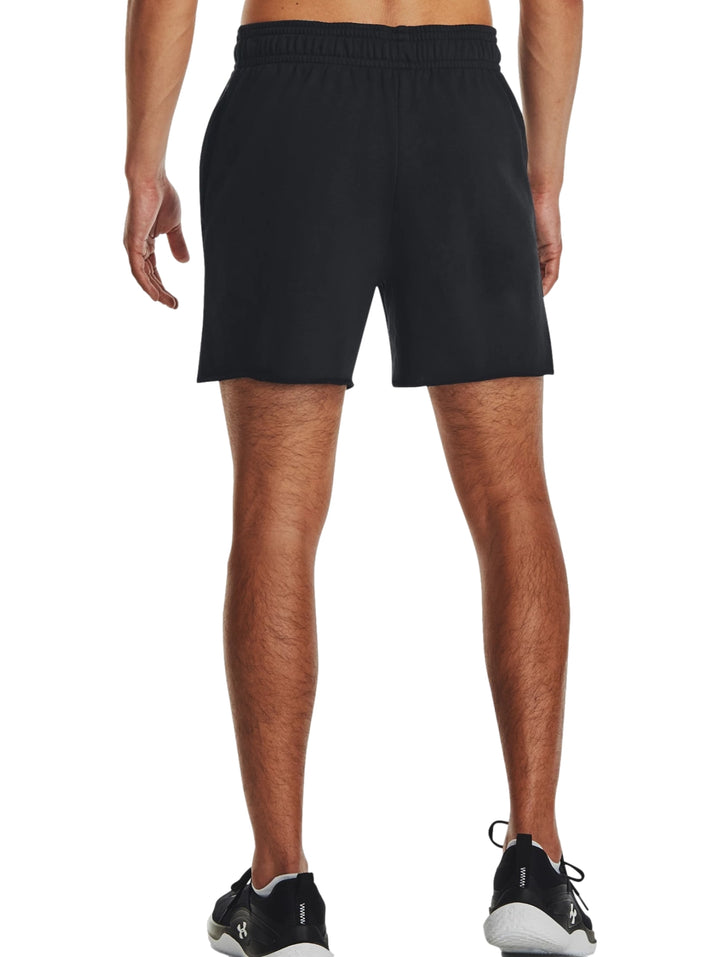 Hombre vistiendo shorts deportivos negros de Under Armour con logo blanco en la pierna derecha.
