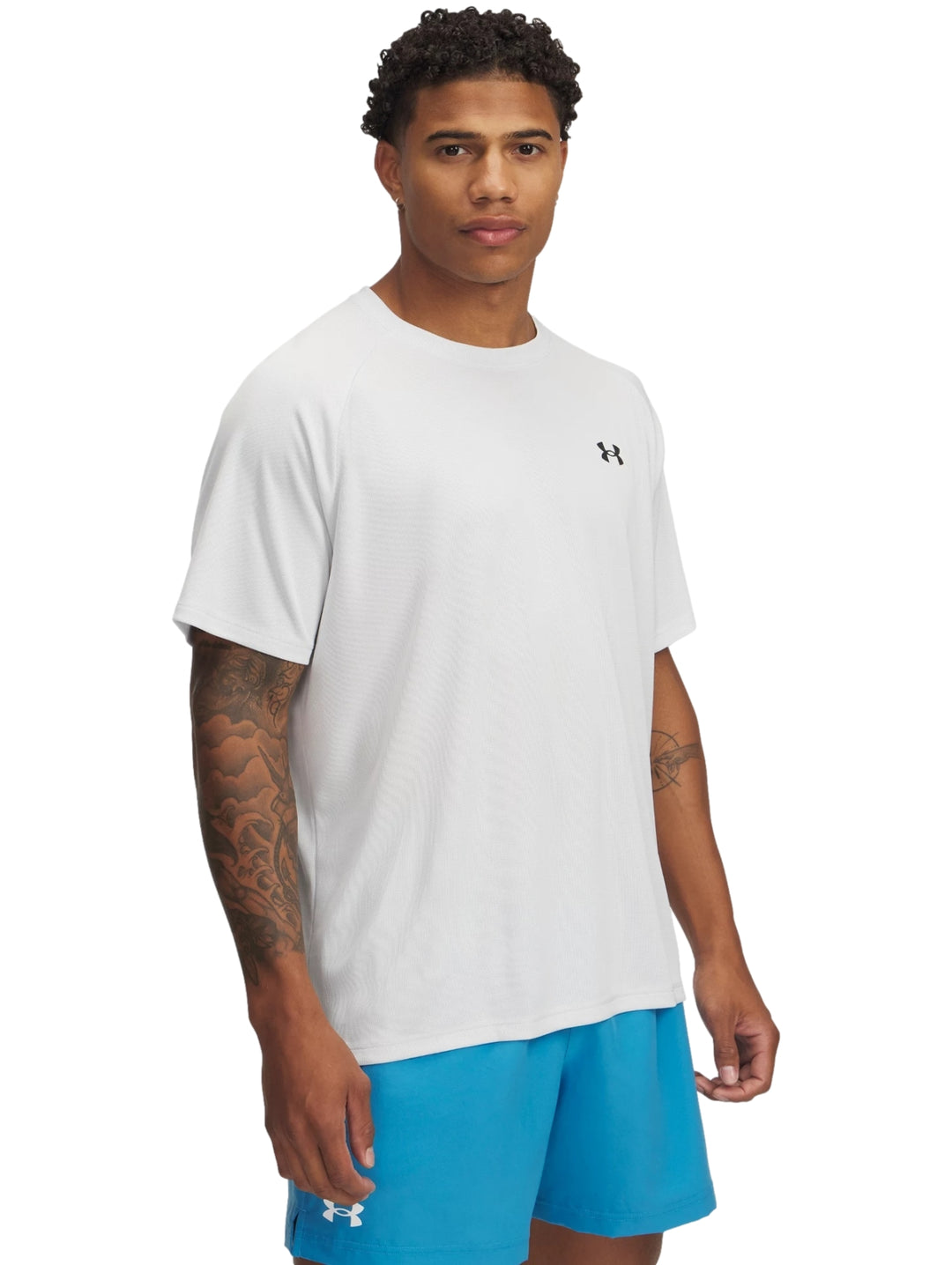 Hombre vistiendo una camiseta deportiva de manga corta color gris de la marca Under Armour.